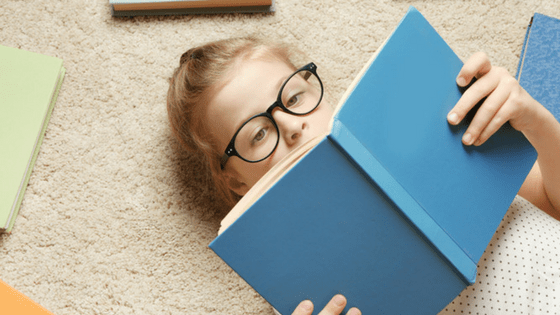 Girl with spectacles reading book