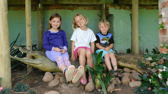 Kids sitting on crocodile