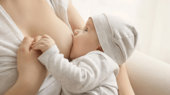 Breastfeeding baby holding hand