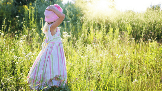 Girl in pink hat playing outside