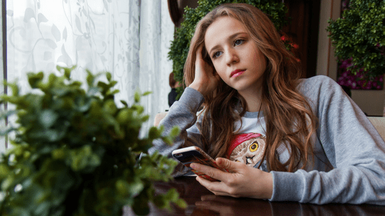 Teenage Girl On Mobile Looking Stressed