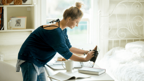 Young woman cleaning laptop