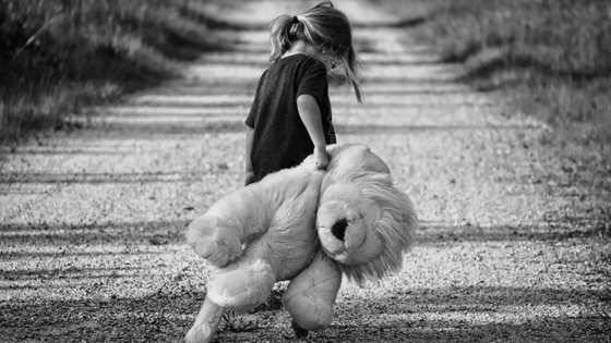 Child walking with stuffed lion