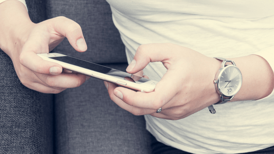 Woman wearing light top using phone