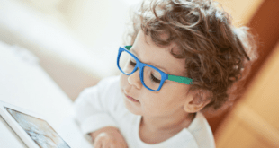 Kid with blue glasses playing with tablet