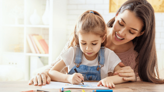 Little girl coloring in with her mom