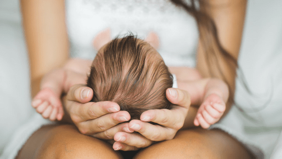 Newborn Baby Lying On Mom's Lap