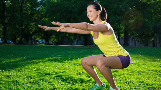 Woman doing squats in garden