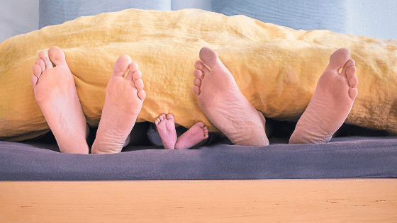 Parents and baby feet in the bed
