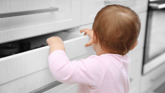 baby exploring kitchen cupboards