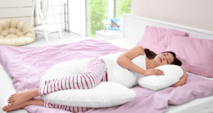 Pregnant woman sleeping on pink duvet
