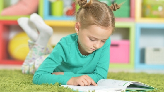 Girl reading book pigtail buns in hair