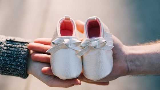 Parents Holding Baby Shoes