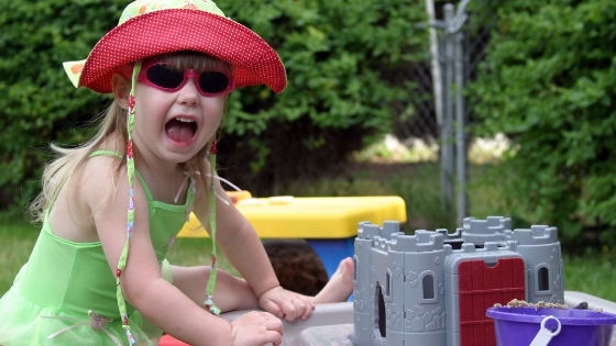 Girl playing outside wearing sun hat