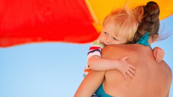 Mom holding baby under umbrella