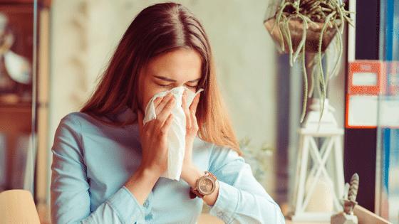 Woman with allergies blowing nose