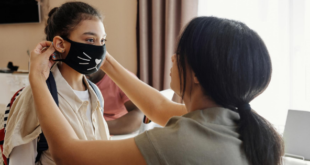 Mother putting mask on daughter