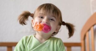 Baby girl with two pacifiers