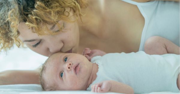 Mom kissing newborn