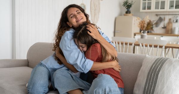 Mom hugging teen daughter